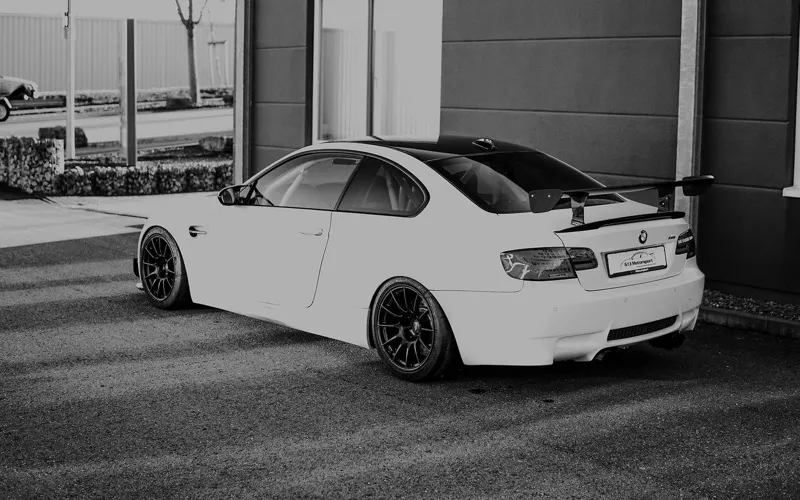BMW M3 E92 mit Rennheckflügel in Schwarz-Weiß, aufgenommen vor dem Hallentor
